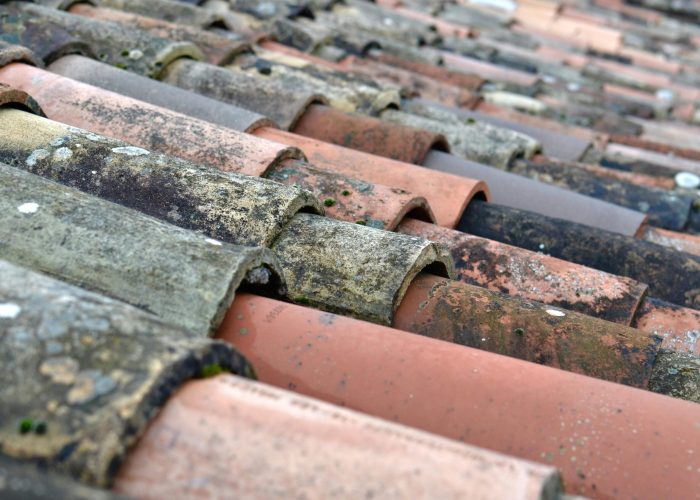 Detailed close-up of weathered terracotta roof shingles in Provence, France.